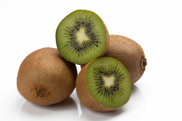 Closeup of three kiwis, two whole and one cut.