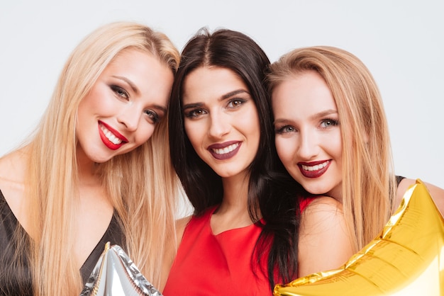 Closeup of three smiling gourgeous girls with bright makeup over white background