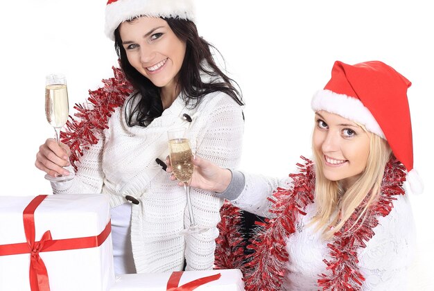 Closeup.three young women in hats of Santa Claus with Christmas gifts and glasses of champagne . the concept of the celebration.