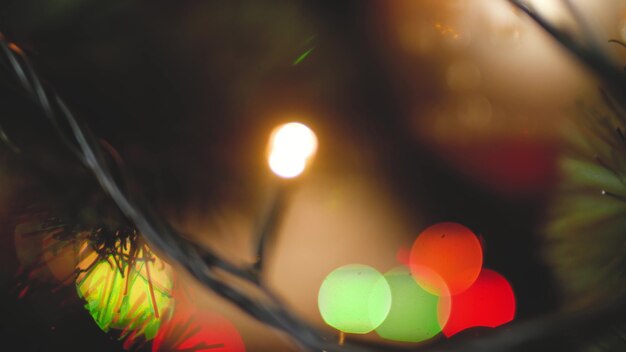 Closeup toned dolly footage of glowing lights, garlands and baubles on Christmas tree