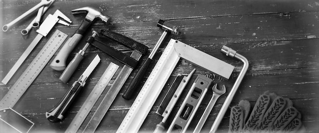closeup tools building and repair set on a vintage wooden background monochrome