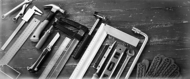 Photo closeup tools building and repair set on a vintage wooden background monochrome