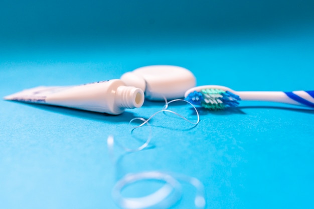 closeup of toothbrush with toothpaste and dental floss.