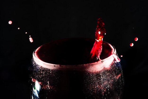 Photo closeup of the top of a clear glass goblet filled with wine with splashes of water splash effect