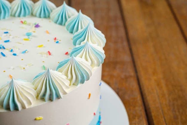 Closeup of the top of vanilla cake with butter cream frosting in the shape of zefir