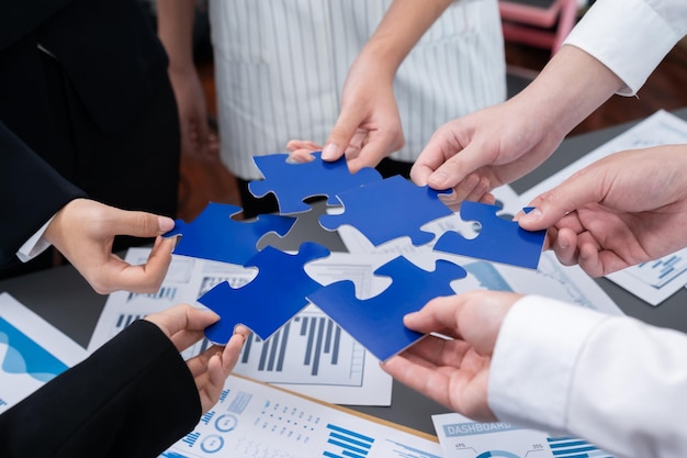 Closeup top view business people join jigsaw puzzle together in harmony office