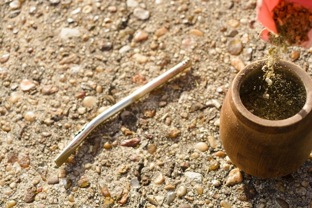 Closeup top view of mate preparation outdoors placing the yerba inside the mate copy space