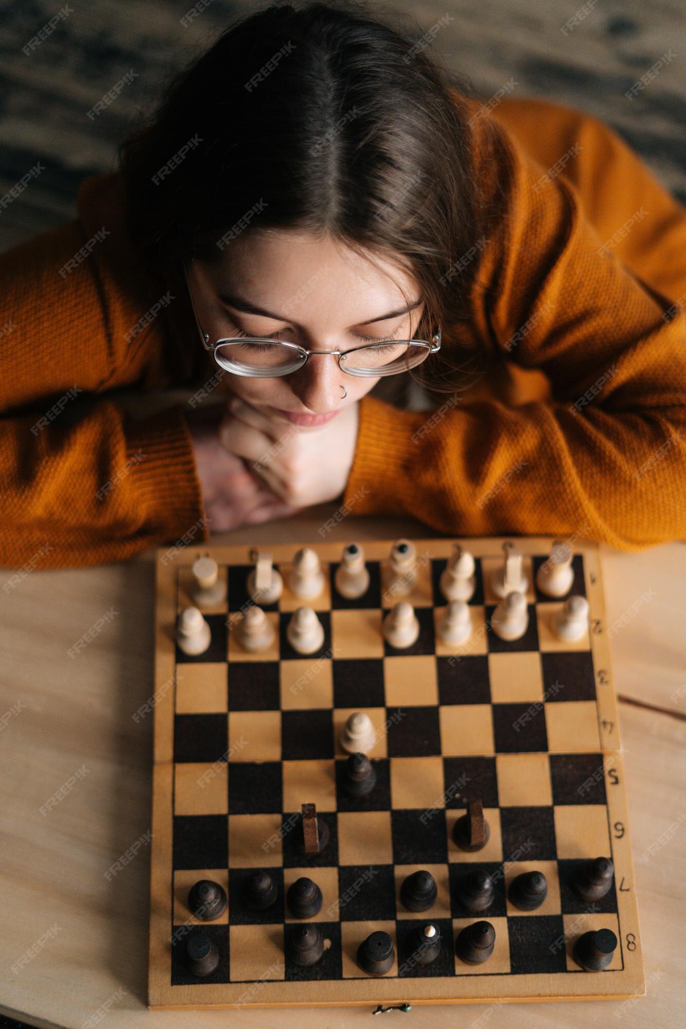 Focused woman thinking about next move and playing chess · Free Stock Photo