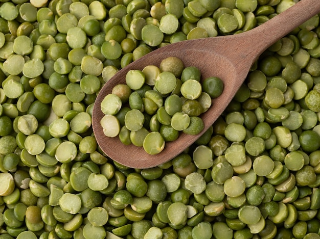 Closeup, top view of raw dried green peas in a spoon.