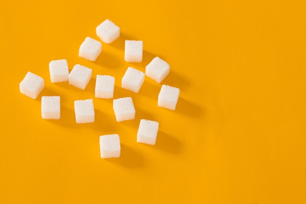 Фото Крупным планом вид сверху кубики сахара на желтом фоне концепция питания и здравоохранения избирательный фокус