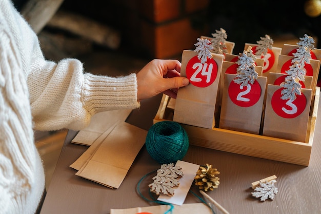 Closeup top view of unrecognizable young woman sticks number on\
craft bag fastens with clothespin