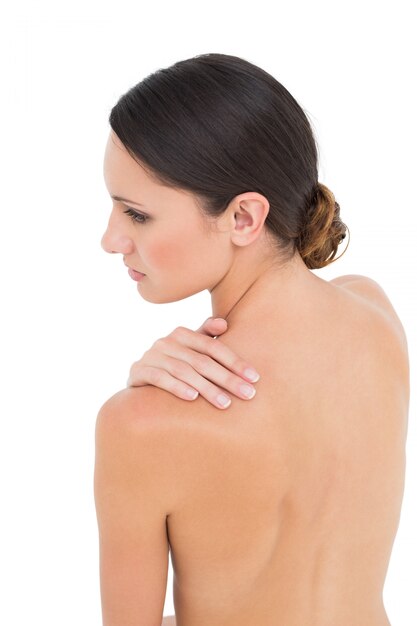 Photo closeup of a topless woman with shoulder pain