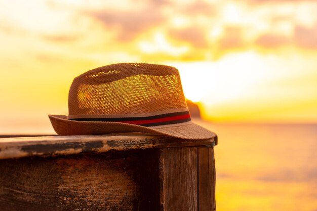 Foto close-up di un cappello turistico al tramonto sulla spiaggia di cala comte a ibiza - concetto di vacanza