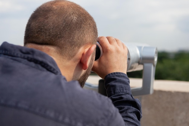 Closeup of tourist looking through binoculars touristic telescope