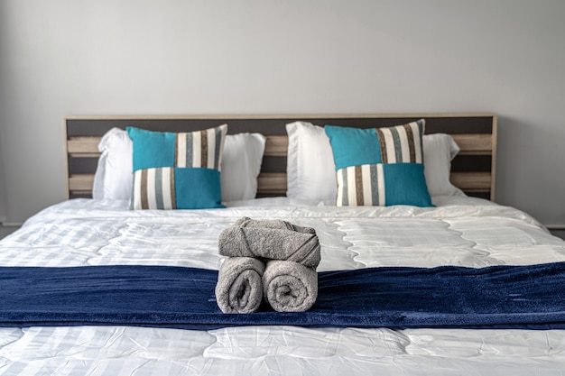 Asciugamano del primo piano sul letto matrimoniale in camera da letto per il servizio al cliente