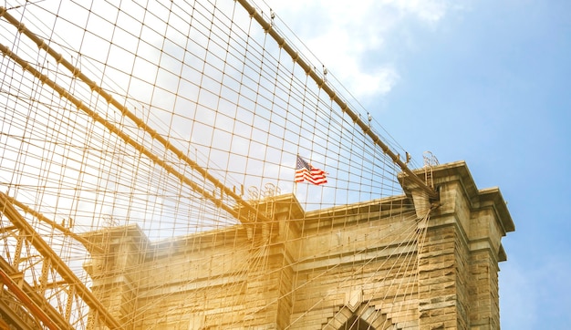ニューヨーク市のブルックリン橋の上の塔とアメリカの国旗のクローズアップ