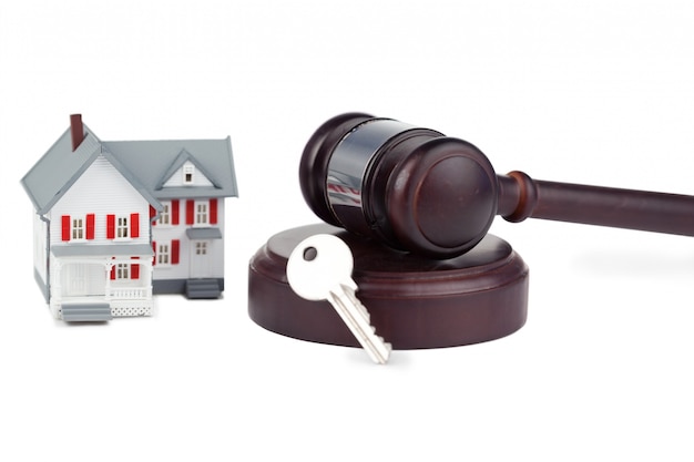 Closeup of a toy house model and a brown gavel