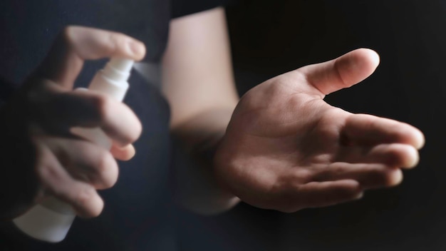 Closeup treatment of hands with alcohol spray