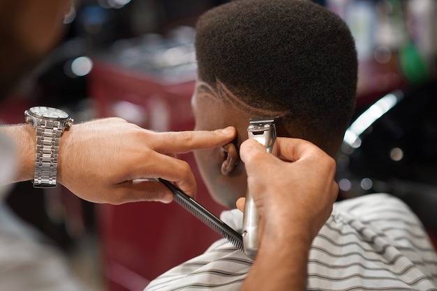 Closeup of trimming stripes on male head in barber shop