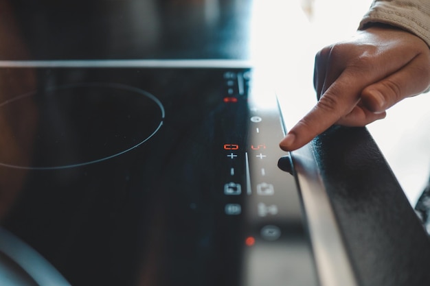 Closeup of turning on electric stove Action Turning on electronic plate panel Panel with touch buttons on electronic plate