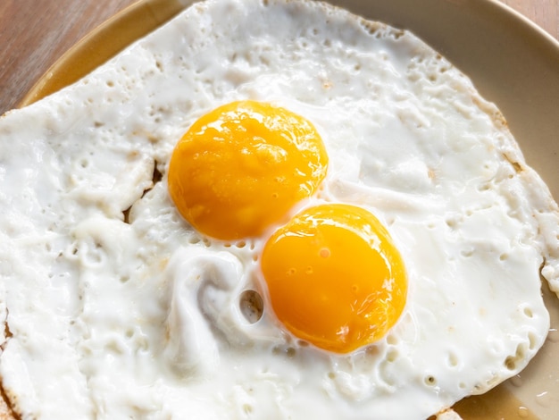 Foto closeup delle uova fritte gemelle per servire nella colazione stile di vita sano nella vita urbana sopra vista con lo spazio di copia