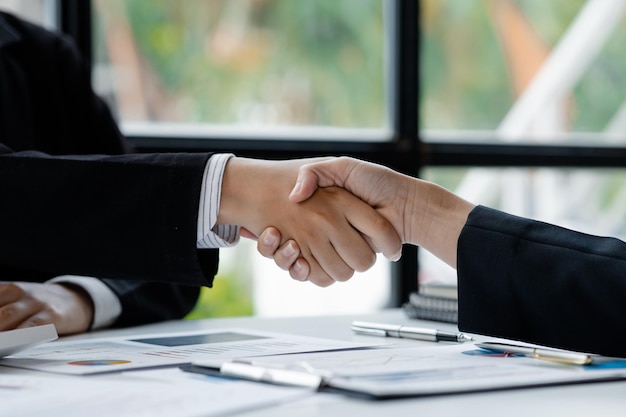 Closeup two business men holding hands Two businessmen are agreeing on business together and shaking hands after a successful negotiation Handshaking is a Western greeting or congratulation