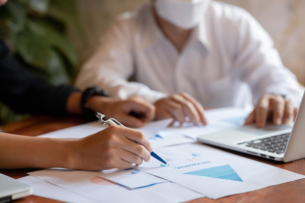 Closeup of two business people meeting to analyze and plan investment marketing financial report data on the table in office Project meeting concept