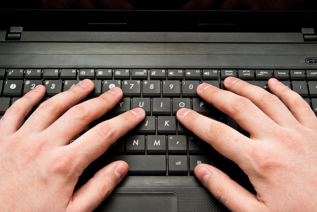 Closeup of two hands over laptop keyboard