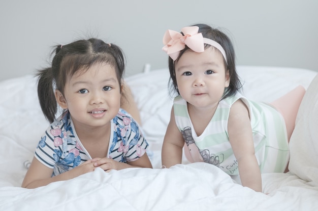 Closeup two little girls on bed