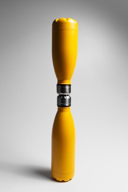 Closeup of two yellow thermo water bottles on grey background Reusable bottle