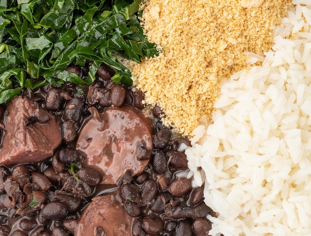 Primo piano della tipica feijoada brasiliana con farofa di riso e cavolo nero