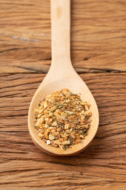 Closeup of typical south american chimichurri on a  spoon over wooden table.