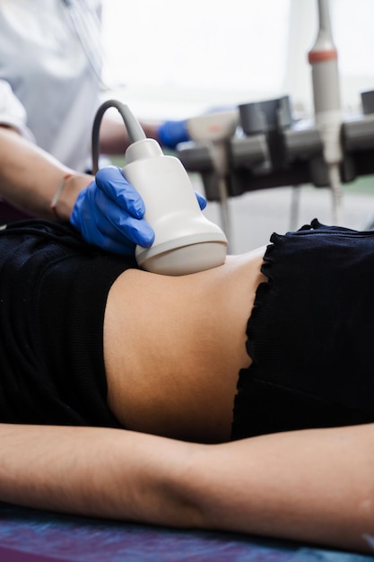 Closeup ultrasound of abdominal organs of girl for diagnosis of liver pancreas gallbladder Abdominal ultrasound for examination of tumors cysts and polyps cirrhosis hepatitis and inflammation