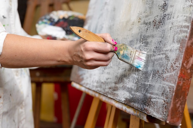 Closeup of an unrecognizable woman painter doing a brush stroke