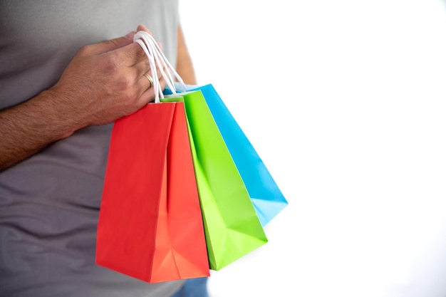 Closeup of unrecognizable young man holding some colorful bags concept shopping black friday sales christmas