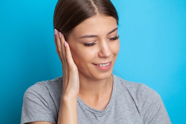 Closeup up side profile sick female having ear pain touching her painful head