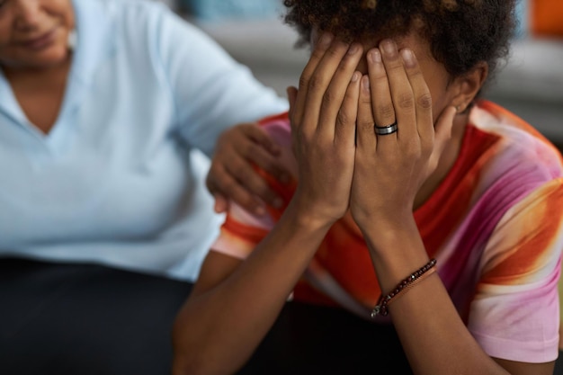 Photo closeup of upset teenage boy covering his face with hands