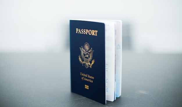 Closeup of a US passport with immigration visa citizenship and travel paperwork on a wooden tabl