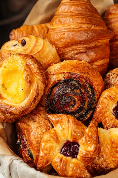 Closeup on variety of sweet fresh baked buns in a basket