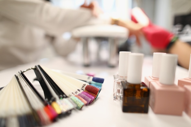 Photo closeup of various colours presented on palette glass tubes with professional nail polish care