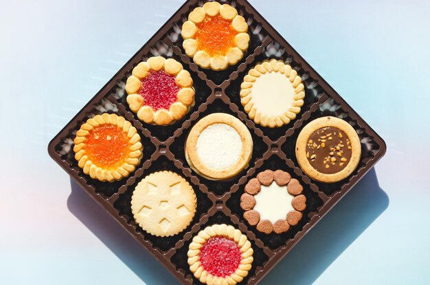 Closeup of various cookies in box on blue background Butter cookies in assortment copy space