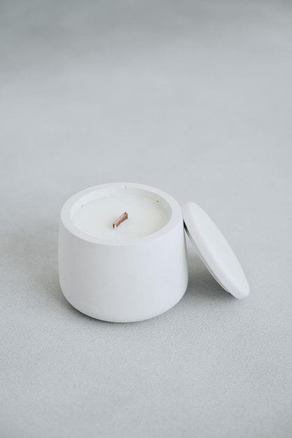 수제 라벨 촛불에 대한 석고 냄비와 뚜껑 장소에 흰색 촛불의 근접 촬영 세로 사진