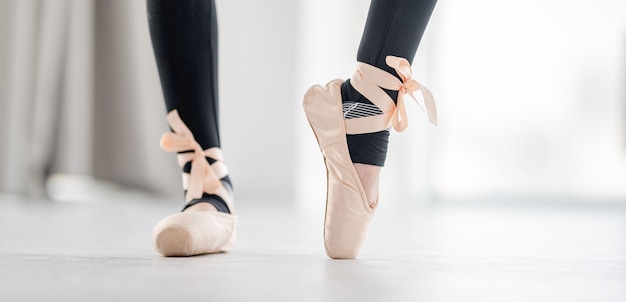 Closeup view on ballerina feet in beige pointe shoes during dance class exercices