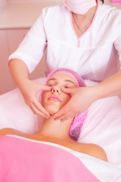 Closeup view of beautiful female face in process of massage and cleaning procedure in cosmetology centre