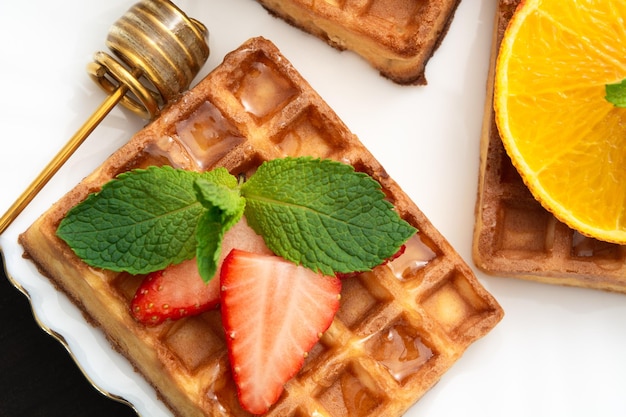 Photo closeup view of belgium waffles with different fruits and berries