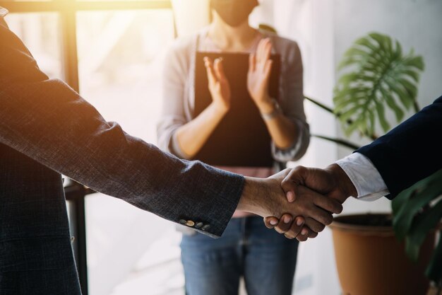 Closeup view of business partnership handshake Photo of two businessman handshaking process Successful deal after great meeting Horizontal flare effect blurred background handshake concept