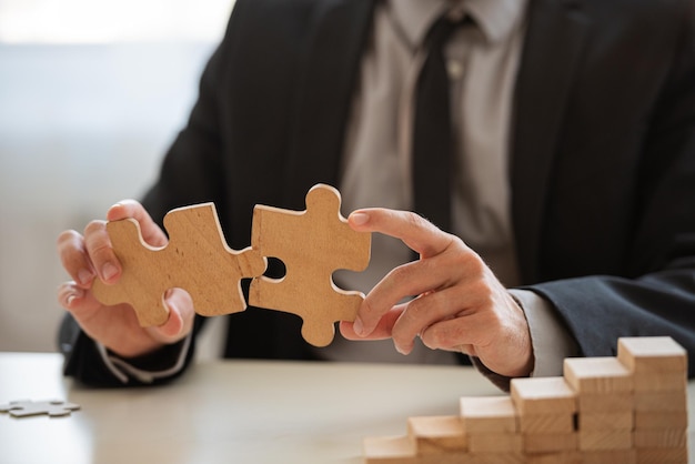 Closeup view of businessman matching two puzzle pieces together