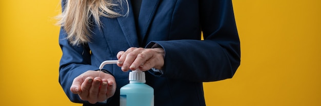 Closeup view of businesswoman applying hand disinfectant to her hands