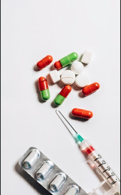 Closeup view of colorful pills and syringe on white medicine and healthcare concept