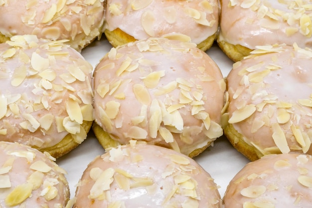 A closeup view of delicious donuts with icing and almond sprinkles